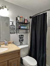 Full bathroom with vanity, toilet, and shower / bathtub combination with curtain