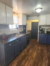 Kitchen with blue cabinetry, white cabinetry, and black dishwasher