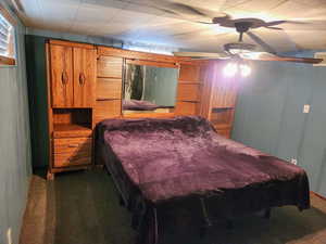 Bedroom with dark colored carpet and ceiling fan