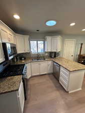 Kitchen featuring white cabinets, light hardwood / wood-style floors, sink, and stainless steel appliances