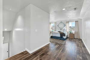 Bedroom featuring a textured ceiling and dark hardwood / wood-style floors