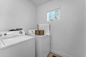 Laundry room featuring washer and dryer and light hardwood / wood-style flooring