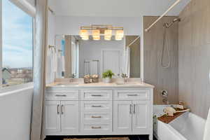 Bathroom featuring vanity and shower / bathtub combination with curtain