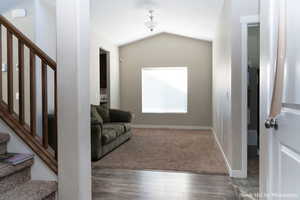 Interior space with dark hardwood / wood-style floors and lofted ceiling