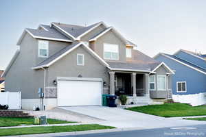 Craftsman inspired home with a garage and a front lawn