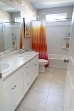 Full bathroom featuring vanity, tile patterned floors, toilet, a textured ceiling, and shower / tub combo