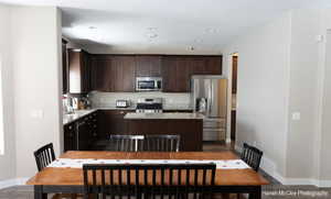 Kitchen featuring sink, dark hardwood / wood-style flooring, a kitchen island, and appliances with stainless steel finishes