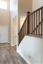 Entryway with a towering ceiling and hardwood / wood-style flooring