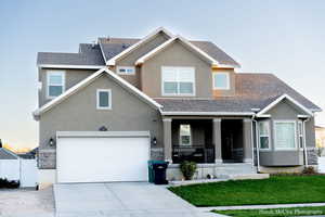 Craftsman house featuring covered porch, a garage, and a front yard