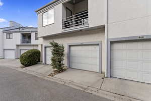 View of property with a balcony and a garage