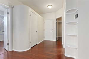 Hall with dark wood-type flooring