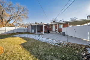 Back of property featuring a yard, a patio area, and a sunroom