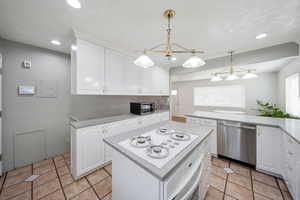 Kitchen with white cabinets, a kitchen island, and appliances with stainless steel finishes