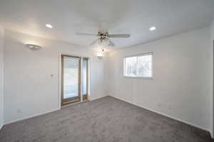 Carpeted spare room featuring ceiling fan