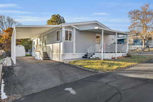 Manufactured / mobile home featuring a shed and a carport