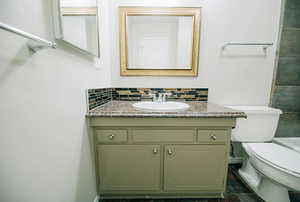 Bathroom with tasteful backsplash, vanity, and toilet