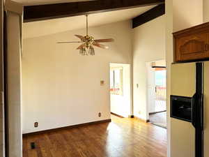 Spare room featuring beamed ceiling, high vaulted ceiling, light hardwood / wood-style flooring, and ceiling fan