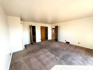 Unfurnished bedroom with dark carpet