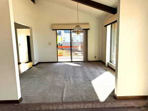 Unfurnished dining area with carpet, beamed ceiling, high vaulted ceiling, and an inviting chandelier