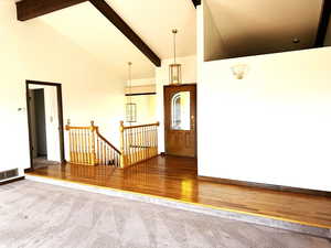 Entryway featuring beam ceiling, hardwood / wood-style flooring, and high vaulted ceiling