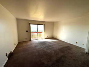 Unfurnished room with dark colored carpet