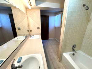 Bathroom featuring tile patterned flooring, vanity, and tiled shower / bath combo