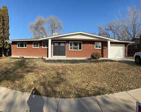 Ranch-style home with a garage and a front yard