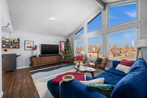 Living room featuring beam ceiling, high vaulted ceiling, indoor bar, and dark hardwood / wood-style floors