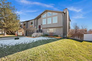 View of front of house with a front lawn and a garage