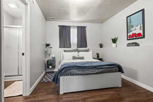 Bedroom featuring dark hardwood / wood-style flooring and a textured ceiling