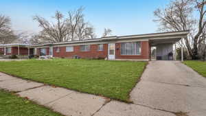 Single story home with a carport, a mountain view, and a front lawn