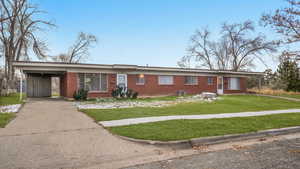 Ranch-style house with a front lawn and a carport