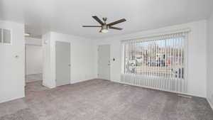 Carpeted spare room featuring ceiling fan