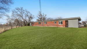 Rear view of house featuring a yard