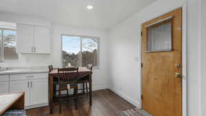 Dining area featuring a healthy amount of sunlight and dark wood-type flooring