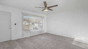 Empty room with ceiling fan and light colored carpet