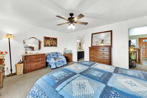 Bedroom featuring carpet, ensuite bathroom, and ceiling fan