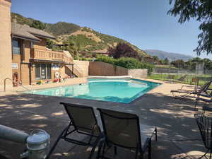 View of pool with a mountain view and a patio