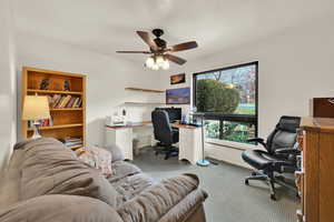 Home office featuring ceiling fan and light carpet