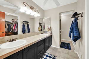 Bathroom with vanity, tile patterned floors, and ceiling fan