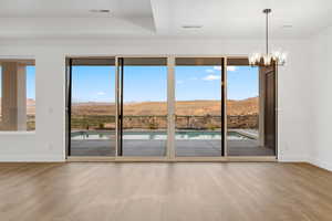 Doorway with a mountain view, wood finished floors, and baseboards