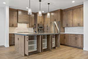 Kitchen featuring backsplash, open shelves, custom exhaust hood, and a sink