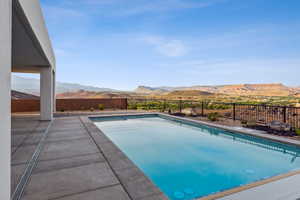 View of pool with a patio, a mountain view, a fenced backyard, and a fenced in pool