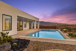 View of pool featuring a mountain view, a fenced in pool, a fenced backyard, and a patio area