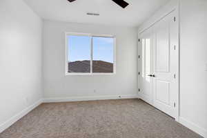 Unfurnished bedroom featuring visible vents, ceiling fan, carpet, and baseboards