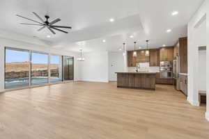 Unfurnished living room with light wood finished floors, recessed lighting, baseboards, and a sink