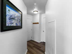 Hallway featuring a textured ceiling and dark hardwood / wood-style flooring