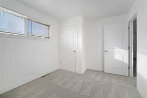 Unfurnished bedroom with light carpet