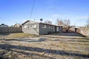 Rear view of house with a lawn and central AC