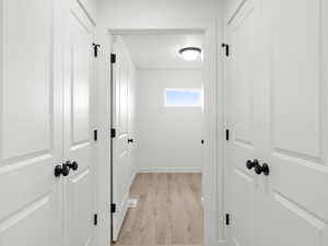 Corridor with light hardwood / wood-style flooring